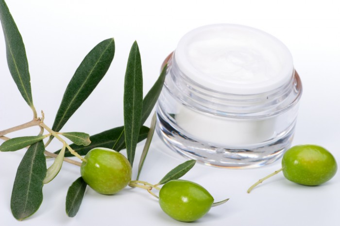 Face cream and twig with green olives