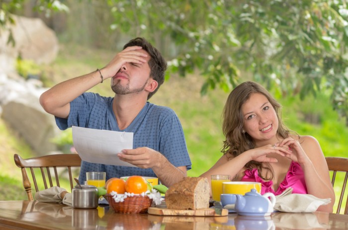 Stressed man and woman arguing about family budget