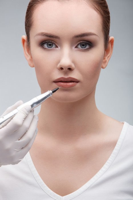 Woman getting permanent makeup on her lips