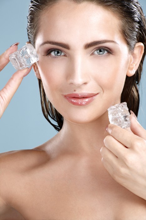 Woman applying ice cube treatment