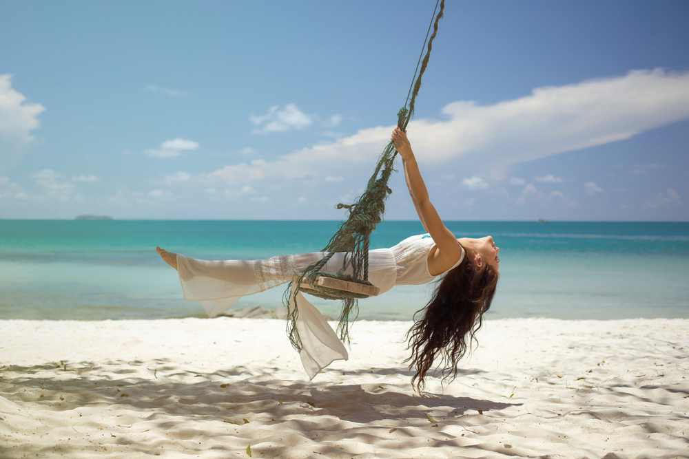 Woman on a swing on the beach