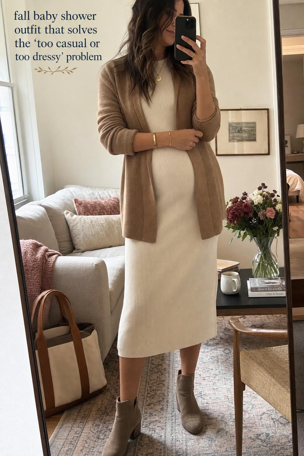 Fall baby shower outfit in a cozy apartment mirror selfie, cream knit midi dress with camel cardigan and ankle boots