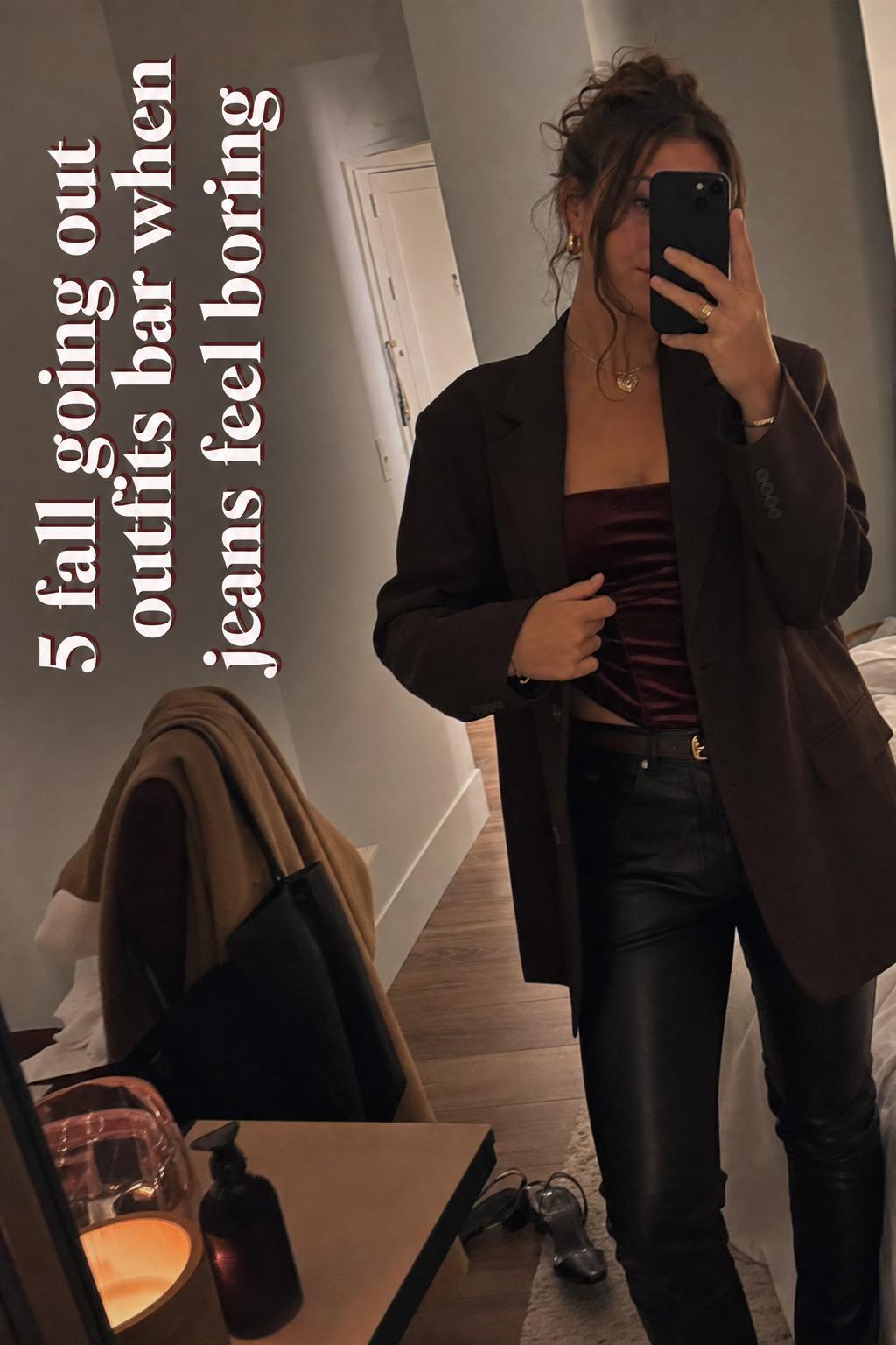 Fall going out outfits bar mirror selfie in a cozy bedroom, woman in blazer and satin top with moody lamp light