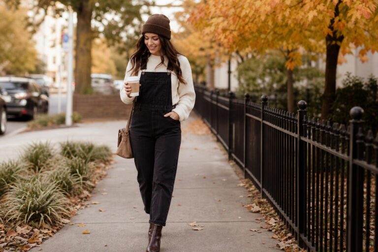 Polished overalls outfit fall look with denim bib overalls, fitted turtleneck, blazer, and ankle boots in autumn light