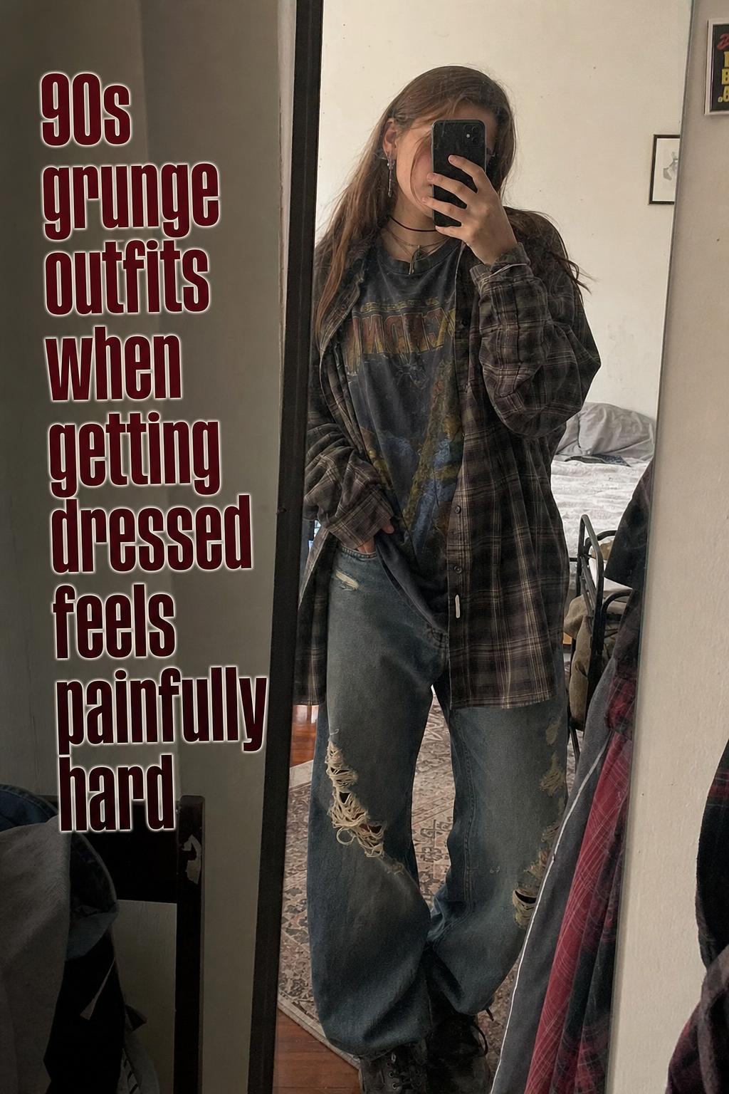 Mirror selfie in a lived-in apartment showing 90s grunge outfits with plaid flannel, band tee, baggy distressed denim and boots.