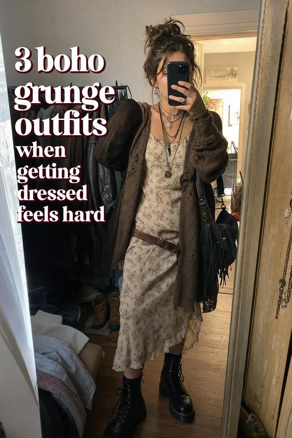 Mirror selfie of boho grunge outfits with floral midi dress, distressed cardigan, combat boots, and layered jewelry in a messy bedroom
