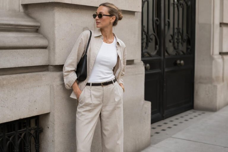 Clean girl style outfits with white tee, straight-leg denim, blazer, loafers, and minimal gold jewelry on a city street