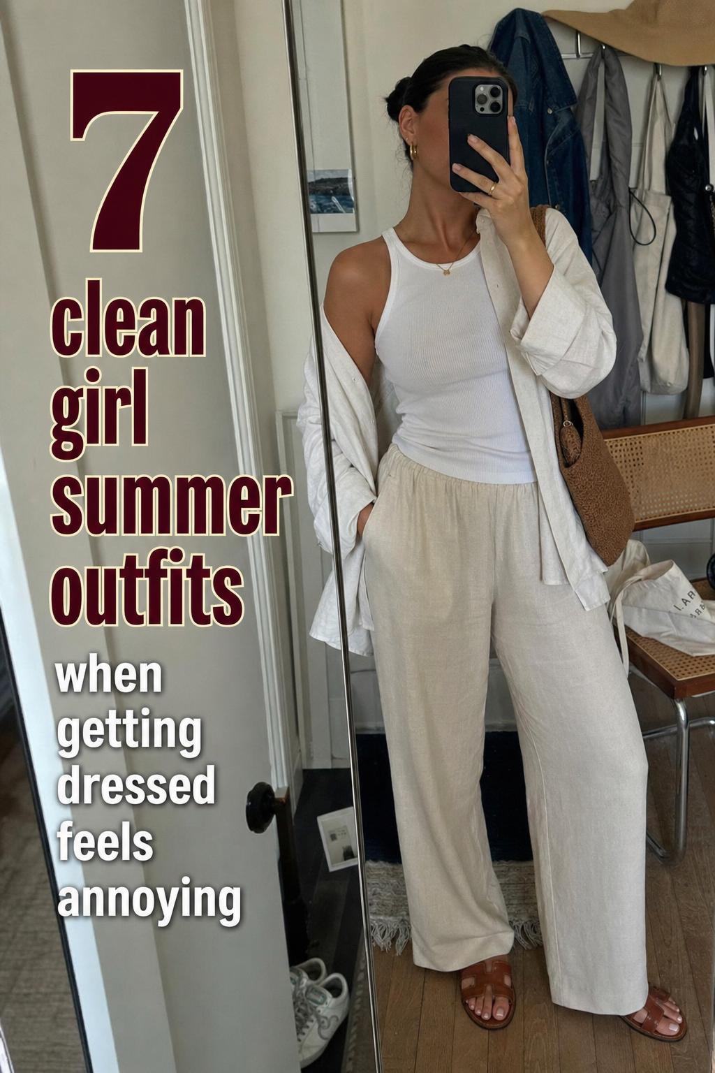 Mirror selfie of clean girl summer outfits: white tank, beige linen trousers, open shirt, sandals in a casual apartment hallway