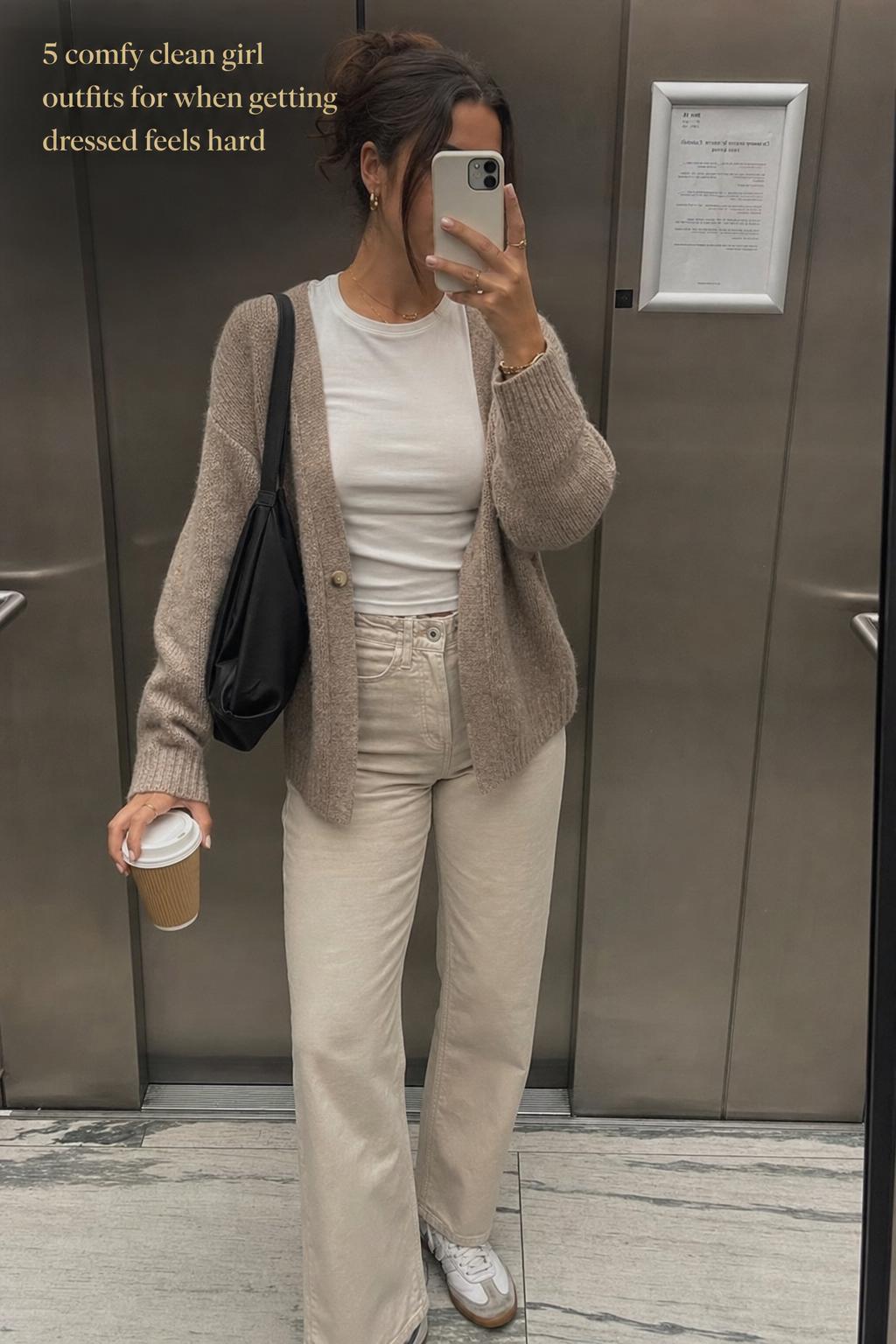 Woman taking elevator mirror selfie in comfy clean girl outfits with neutral blazer, white tee, denim and sneakers