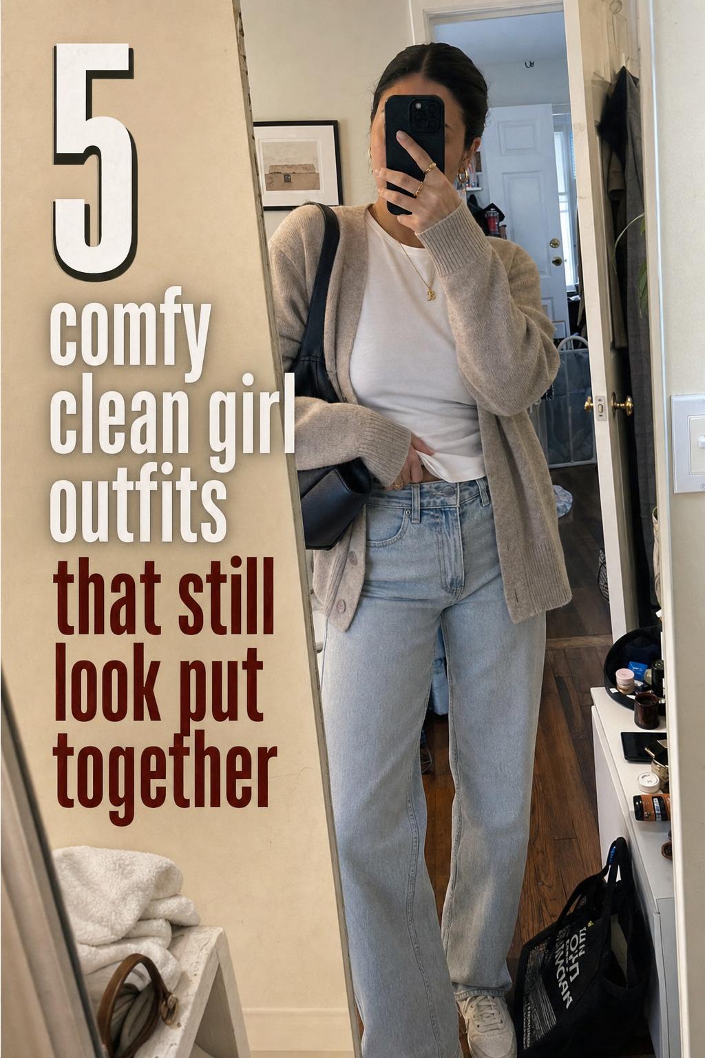 Mirror selfie in lived-in apartment wearing comfy clean girl outfits: white tee, light-wash jeans, cardigan, sneakers, gold jewelry.
