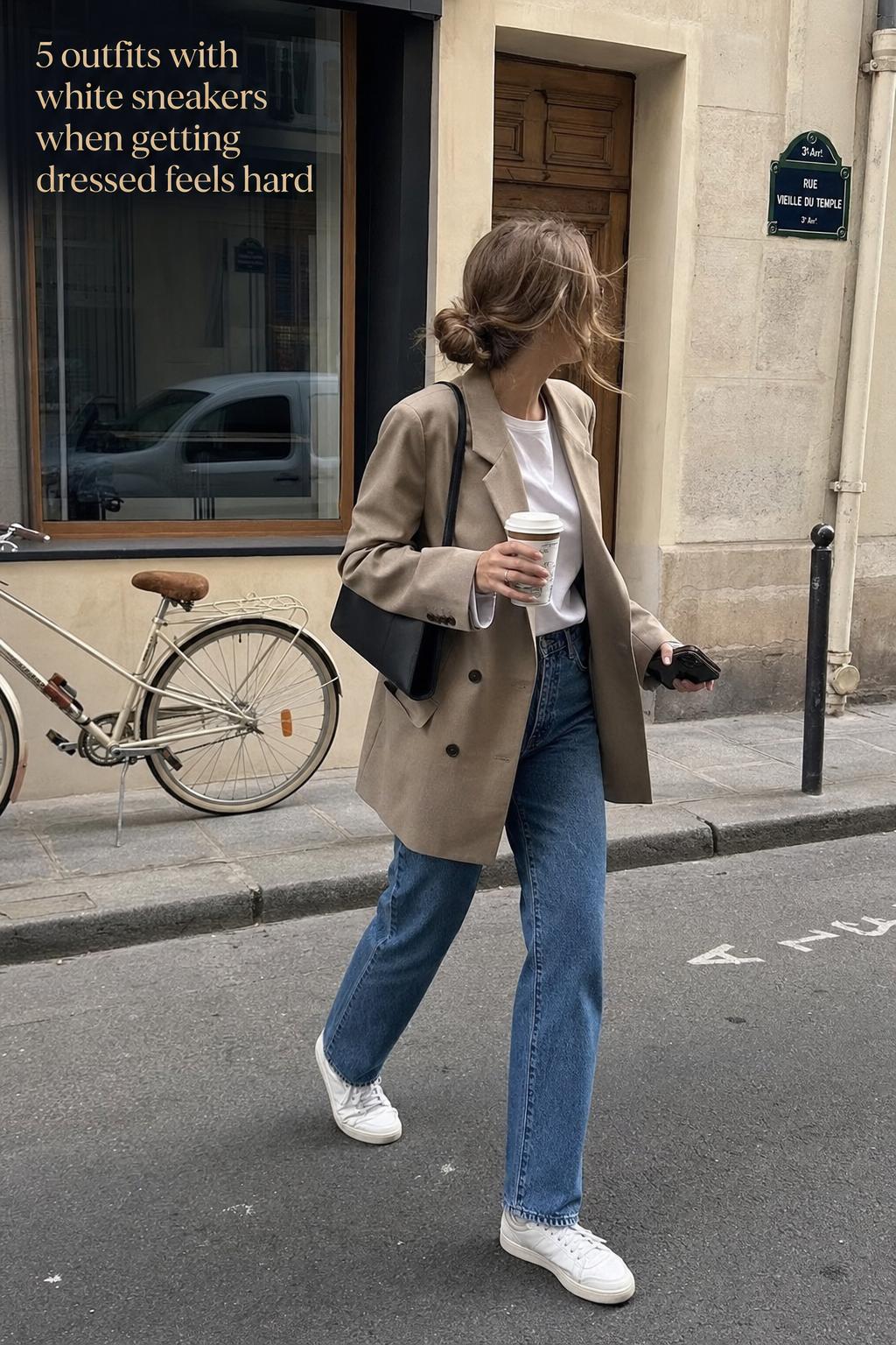 Candid street-style photo of outfits with white sneakers, blazer and jeans with coffee on a city sidewalk