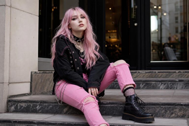 Pink alternative fashion outfit with black jacket, pink denim, and chunky boots styled for a modern streetwear look