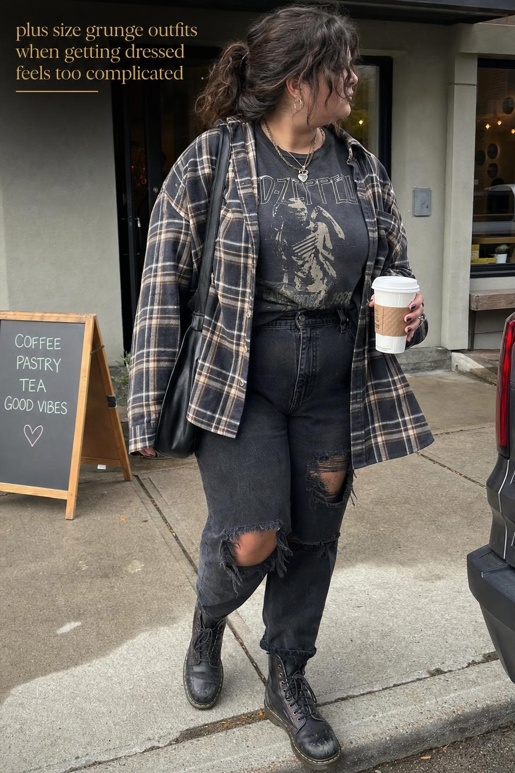 Plus size grunge outfits on a cloudy city sidewalk with plaid flannel, band tee, ripped black jeans, and combat boots