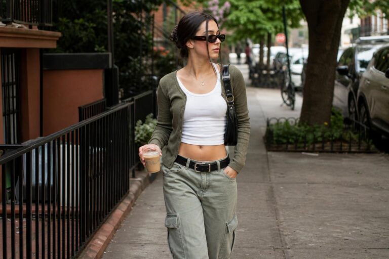 Real y2k outfits with baby tee, relaxed low-rise denim, chunky sneakers and a compact shoulder bag on a city street