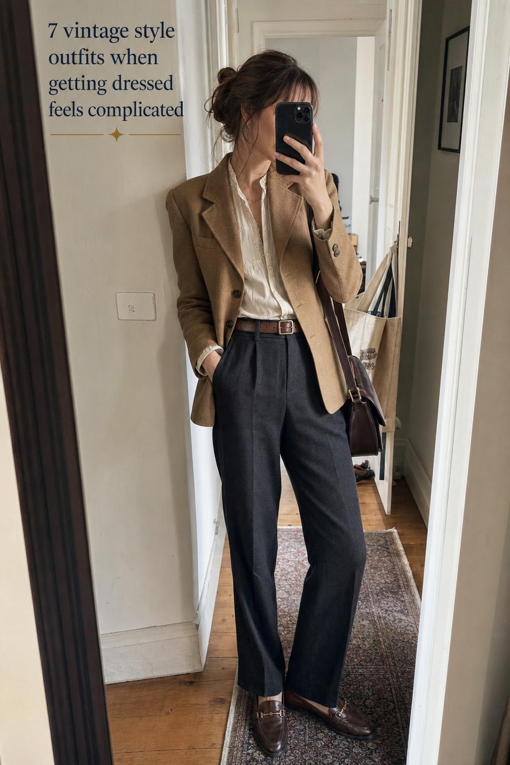Vintage style outfits mirror selfie in a hallway featuring camel blazer, cream blouse, high-waist trousers and loafers