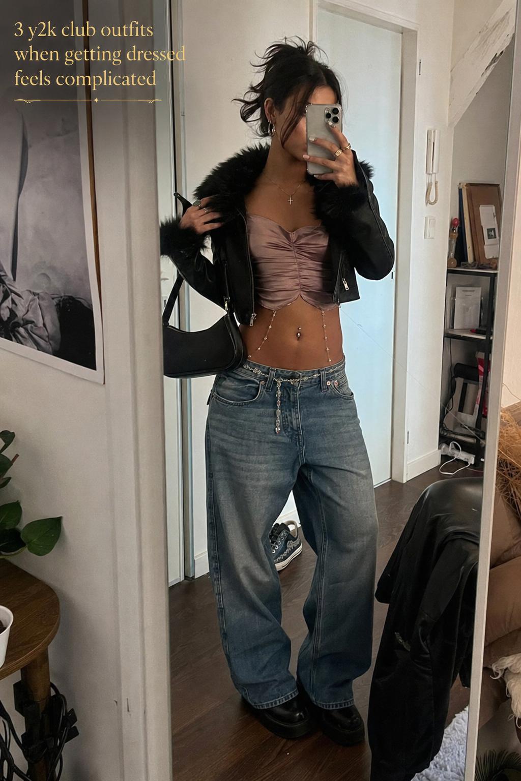Mirror selfie in a messy bedroom showing y2k club outfits with satin top, low-rise cargos, cropped blazer and platform boots