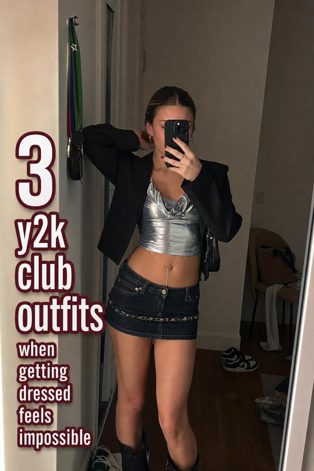 Real woman mirror selfie in messy apartment wearing y2k club outfits with silver top, cropped blazer, and low-rise denim