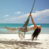 Woman on a swing on the beach